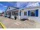 Exterior of a community building, featuring white siding with blue trim and well maintained landscaping at 10315 Cortez W Rd # 16E, Bradenton, FL 34210