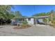 Exterior view of home with carport, front porch and blue entry door at 1121 Franklin Ave, Ellenton, FL 34222