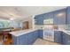 Blue kitchen with breakfast bar, white counters and stainless appliances at 1121 Franklin Ave, Ellenton, FL 34222