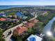 Aerial view of waterfront property with lush surroundings, a terracotta roof, and canal access at 12518 Harbour Landings Dr, Cortez, FL 34215