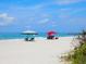 Sunny beach scene featuring people relaxing under beach canopies at 12518 Harbour Landings Dr, Cortez, FL 34215