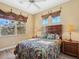 Well-lit bedroom showcasing a unique headboard, two windows, and side tables with lamps at 12518 Harbour Landings Dr, Cortez, FL 34215