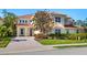 Two-story home with a terracotta tile roof, a paver driveway, and lush landscaping at 12518 Harbour Landings Dr, Cortez, FL 34215