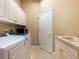 Functional laundry room featuring modern washer and dryer, ample storage, and utility sink at 12518 Harbour Landings Dr, Cortez, FL 34215