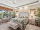 Tranquil main bedroom with neutral tones, tray ceiling, leafy decor, and ample natural light at 12518 Harbour Landings Dr, Cortez, FL 34215
