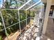 Screened porch area with spiral staircase and view of the lush greenery at 12518 Harbour Landings Dr, Cortez, FL 34215