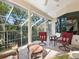 Relaxing screened porch with cushioned seating, ceiling fan, and views of the lush backyard at 12518 Harbour Landings Dr, Cortez, FL 34215