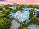 Stunning three-story coastal home boasting a rooftop deck and multiple balconies, set amidst lush tropical landscaping at 141 Avenida Veneccia, Sarasota, FL 34242