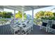 Covered patio boasts dining table for eight, with outdoor chairs and bright tropical backdrop at 141 Avenida Veneccia, Sarasota, FL 34242