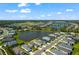A picturesque aerial view of a residential neighborhood featuring homes surrounding a large pond under a partly cloudy sky at 14147 Campfire Ct, Parrish, FL 34219
