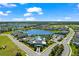 Expansive aerial view of a lakeside community with a pool, clubhouse, and manicured landscaping at 14147 Campfire Ct, Parrish, FL 34219