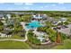 Stunning aerial view of a resort-style pool with lush landscaping, sun loungers, and community buildings at 14147 Campfire Ct, Parrish, FL 34219