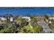 Aerial view of a tree lined neighborhood on the water with tennis courts at 1440 Kimlira Ln, Sarasota, FL 34231