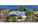 Aerial view of a charming home with a gray roof nestled among lush greenery at 1440 Kimlira Ln, Sarasota, FL 34231