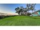 Large grassy backyard with mature trees, water views, and a tranquil setting at 1440 Kimlira Ln, Sarasota, FL 34231