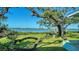 Picturesque backyard view with mature trees, green lawn, and tranquil waterfront setting at 1440 Kimlira Ln, Sarasota, FL 34231