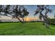 Lush backyard featuring well-manicured lawn, mature trees, and a stunning waterfront view at 1440 Kimlira Ln, Sarasota, FL 34231