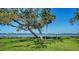 Backyard with mature trees providing shade and beautiful water views at 1440 Kimlira Ln, Sarasota, FL 34231