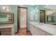 Bright bathroom featuring stylish blue geometric tiles, sleek white vanity, and a glass-enclosed shower at 1440 Kimlira Ln, Sarasota, FL 34231