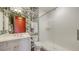 Bright bathroom with a glass shower, toucan wallpaper, and a vanity with a white countertop at 1440 Kimlira Ln, Sarasota, FL 34231