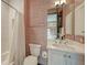 Stylish bathroom featuring unique patterned wallpaper, a shower-tub combo, and sleek white vanity at 1440 Kimlira Ln, Sarasota, FL 34231