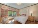 Bright bedroom with patterned curtains, a bed with carved headboard and beautiful outdoor view at 1440 Kimlira Ln, Sarasota, FL 34231