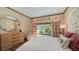 Bright bedroom with patterned curtains, a bed with carved headboard and beautiful outdoor view at 1440 Kimlira Ln, Sarasota, FL 34231