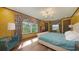 Bright bedroom with patterned wallpaper, modern chandelier, and a comfortable upholstered chair at 1440 Kimlira Ln, Sarasota, FL 34231