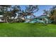 Charming turquoise home with a blue roof and mature trees on a lush green lawn at 1440 Kimlira Ln, Sarasota, FL 34231