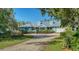 Inviting home exterior with well-manicured landscaping and a peaceful setting; surrounded by mature trees at 1440 Kimlira Ln, Sarasota, FL 34231
