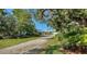 Charming home exterior with a long driveway, lush landscaping, and a welcoming facade at 1440 Kimlira Ln, Sarasota, FL 34231
