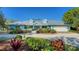 Charming home with lush landscaping, dormer windows, and a long paved driveway at 1440 Kimlira Ln, Sarasota, FL 34231