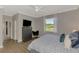 Bedroom featuring wood floors, a ceiling fan and a black dresser with a TV at 167 Wandering Wetlands Cir, Bradenton, FL 34212