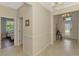 Bright hallway featuring neutral walls, tile flooring, and access to the front entry and bedroom at 167 Wandering Wetlands Cir, Bradenton, FL 34212