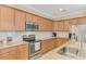 Spacious kitchen features wooden cabinetry, granite countertops, stainless steel appliances, and a white tile backsplash at 167 Wandering Wetlands Cir, Bradenton, FL 34212