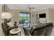 Bright living room featuring dark leather sofas, neutral decor, tile flooring, and a screened patio at 167 Wandering Wetlands Cir, Bradenton, FL 34212
