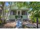 Charming cottage-style home with a quaint front porch and lush tropical landscaping at 1679 Arlington St, Sarasota, FL 34239
