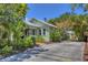 Charming green home surrounded by mature trees and landscaping, featuring a concrete driveway at 1679 Arlington St, Sarasota, FL 34239