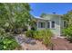 Charming exterior of a cottage-style home surrounded by lush landscaping and a quaint walkway at 1679 Arlington St, Sarasota, FL 34239