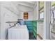 Bright laundry room with washing machine, water heater, and wooden shelving at 1679 Arlington St, Sarasota, FL 34239