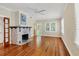 Bright living room with a decorative fireplace, ceiling fan and gleaming hardwood floors at 1679 Arlington St, Sarasota, FL 34239