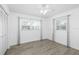 Bedroom featuring wood floors, ceiling fan, windows with curtains, and a closet for storage at 1827 Nevada Ne Ave, St Petersburg, FL 33703
