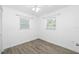 Bedroom with wood floors, two windows with blinds, and a ceiling fan, all in a neutral color palette at 1827 Nevada Ne Ave, St Petersburg, FL 33703