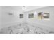 Bright bedroom with modern light fixture, marble floors and views of the neighborhood through large windows at 1827 Nevada Ne Ave, St Petersburg, FL 33703