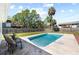 Backyard featuring a swimming pool, green grass, trees, and a fence for privacy at 1827 Nevada Ne Ave, St Petersburg, FL 33703