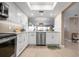 Modern kitchen features stainless steel appliances, white cabinets, stone countertops and plank flooring at 1900 Cove Ii Pl # 133, Sarasota, FL 34242