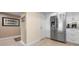 Bright kitchen featuring modern stainless steel refrigerator, white cabinetry, and tile flooring at 1900 Cove Ii Pl # 133, Sarasota, FL 34242