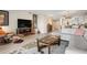 Spacious living room with modern furniture, a large TV, and views into the dining and kitchen areas at 1900 Cove Ii Pl # 133, Sarasota, FL 34242