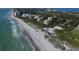 An aerial view captures beachfront residences, the coastline, and beach pavilions at 1930 Harbourside Dr # 142, Longboat Key, FL 34228