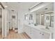 Bright bathroom featuring double sinks, a large mirror, and linen storage at 1930 Harbourside Dr # 142, Longboat Key, FL 34228